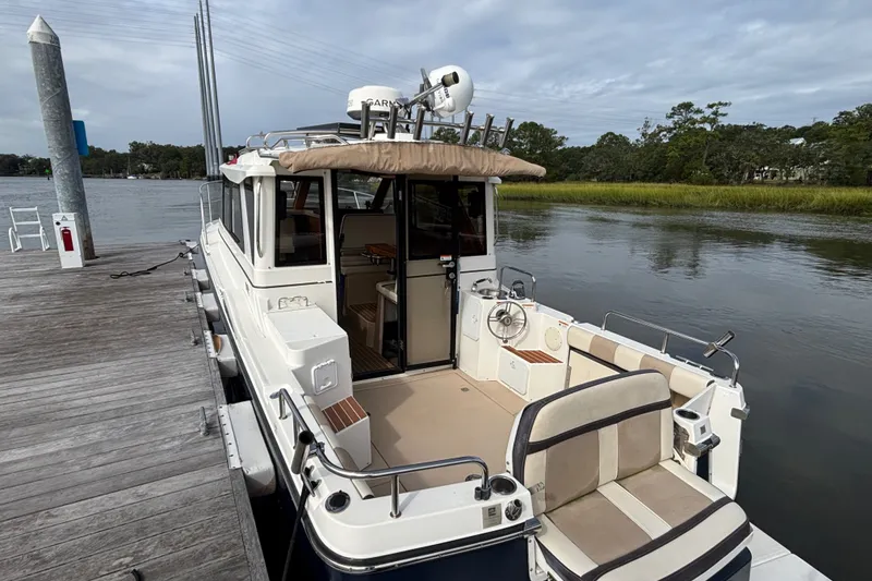 Slide: The Image of 2016 Cutwater C-28 boat docked port side to showcasing the roomy cockpit, reversible aft seat, cockpit helm controls and sunbrella sun shade (not deployed) - 11