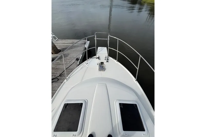 Slide: The Image of 2016 Cutwater C-28 boat bow view at dock, featuring deck and railing. - 18