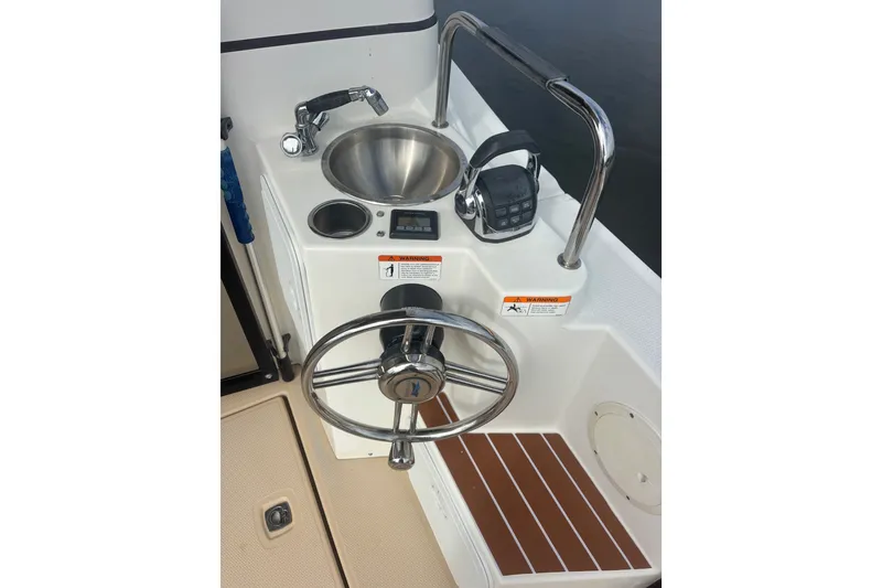 Slide: The Image of 2016 Cutwater C-28 Cockpit helm with steering wheel, sink, and control panel. - 14