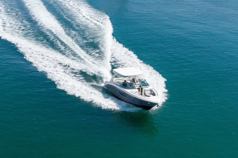 Slide: The Image of 2023 Regal 3300 Bowrider cruising on clear blue water, leaving a wake trail. - 3