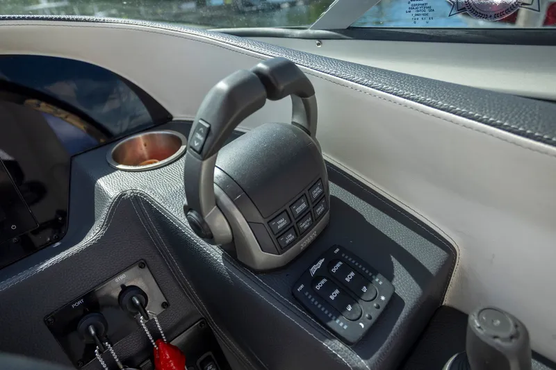 Slide: The Image of 2023 Regal 3300 Bowrider helm controls with modern dashboard and cup holder. - 21
