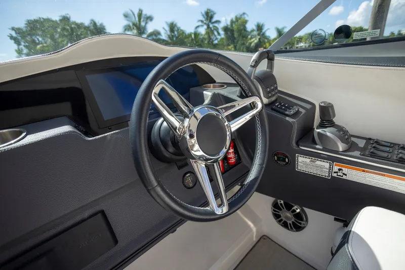 Slide: The Image of 2023 Regal 3300 Bowrider helm with modern steering wheel and controls. - 18