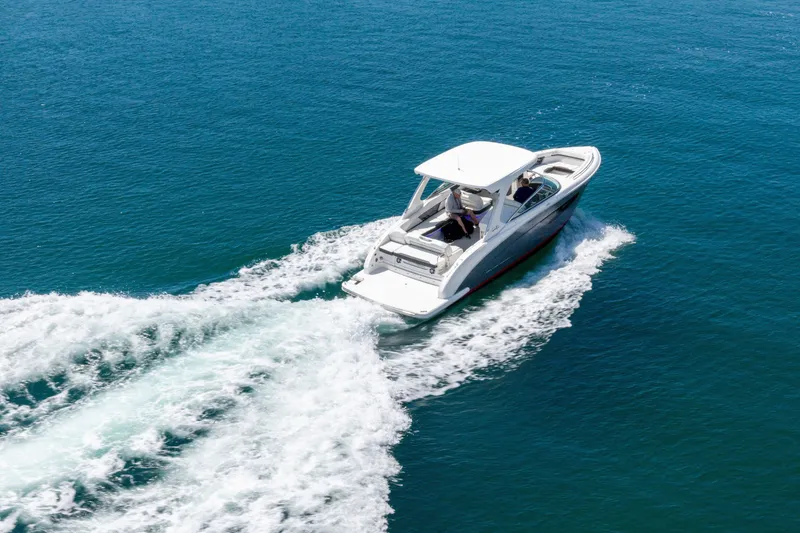 Slide: The Image of 2023 Regal 3300 Bowrider cruising on open blue water. - 8