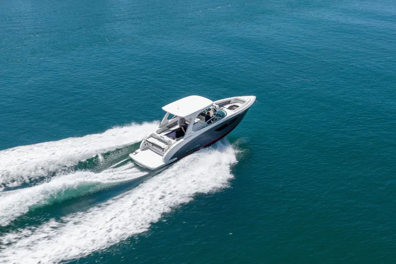 Slide: The Image of 2023 Regal 3300 Bowrider cruising on open blue water. - 2