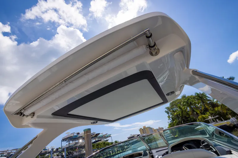 Slide: The Image of 2023 Regal 3300 Bowrider boat canopy under blue sky with clouds. - 10