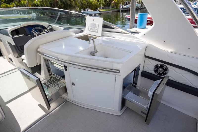 Slide: The Image of 2023 Regal 3300 Bowrider boat interior with sink, storage, and seating area. - 14