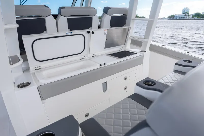 Slide: The Image of 2022 Pursuit S 428 Sport boat interior with seating and storage, overlooking water. - 16