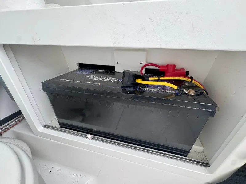 Slide: The Image of Battery in a compartment of a 2019 Sportsman Open 252 Center Console boat. - 23