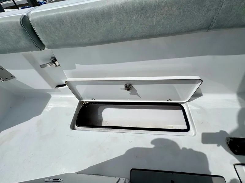 Slide: The Image of An open storage compartment on a 2019 Sportsman Open 252 Center Console boat. - 17