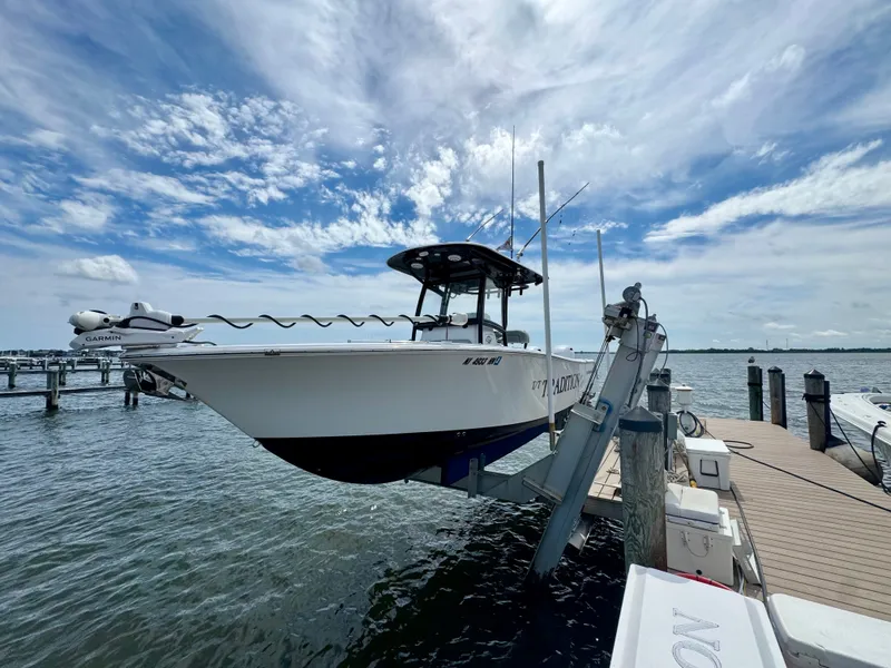Slide: The Image of A 2019 Sportsman Open 252 Center Console boat is lifted at a dock. - 25