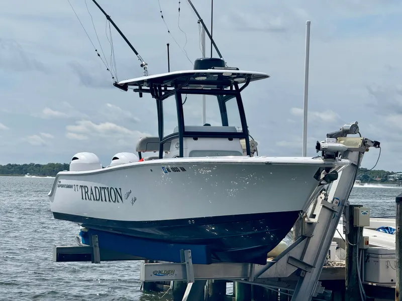 The Image of A 2019 Sportsman Open 252 Center Console boat on a lift by the water. - 0