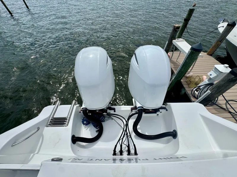 Slide: The Image of Two outboard engines on a sports boat docked, overlooking the water. - 16