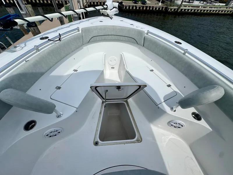 Slide: The Image of The image shows the bow of a 2019 Sportsman Open 252 Center Console boat with storage space. - 24