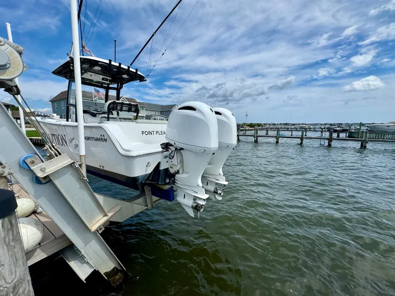 Slide: The Image of A 2019 Sportsman Open 252 Center Console boat with twin outboard engines at the dock. - 26