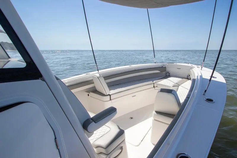 Slide: The Image of Manufacturer Provided Image: 2026 Regulator 25 boat interior with cushioned seating, ocean view, and canopy shade. - 3