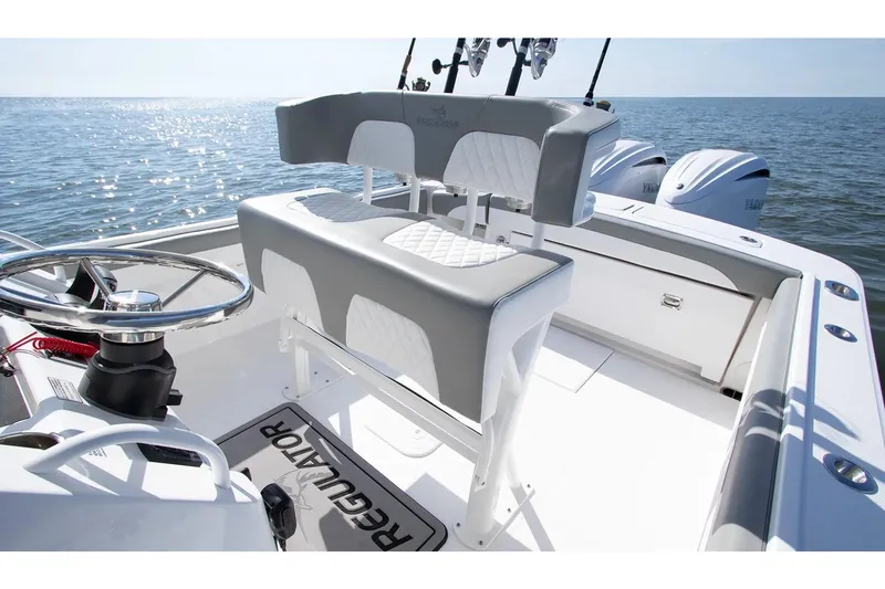 Slide: The Image of Manufacturer Provided Image: 2026 Regulator 25 boat interior with helm and seating, overlooking calm ocean waters. - 6