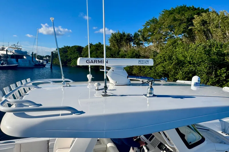 Slide: The Image of 2020 Intrepid 375 Nomad SE boat with Garmin radar, docked near lush greenery. - 15