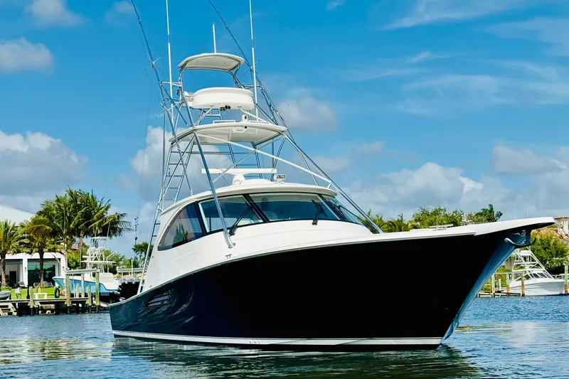 Slide: The Image of 2017 Viking 52 Sport Tower yacht on calm water, clear sky background. - 3