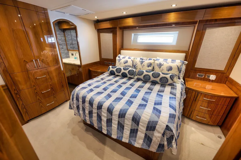 Slide: The Image of Luxurious bedroom interior of 2015 Hatteras GT70 yacht with elegant wood finishes and nautical bedding. - 42