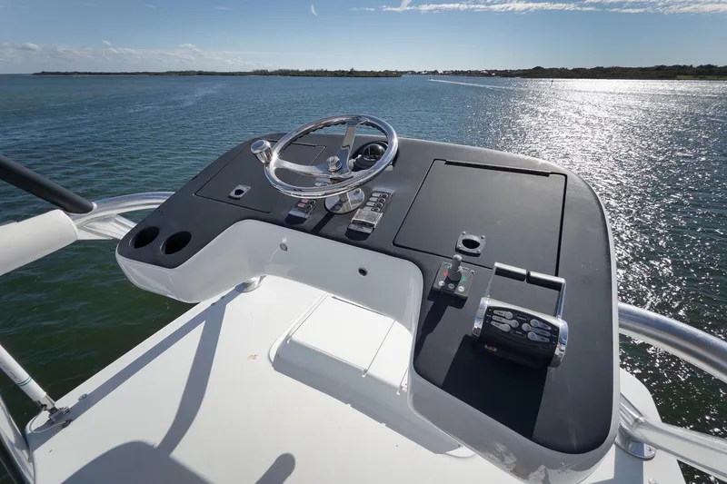 Slide: The Image of Helm of 2015 Hatteras GT70 yacht overlooking serene water and distant shoreline. - 78