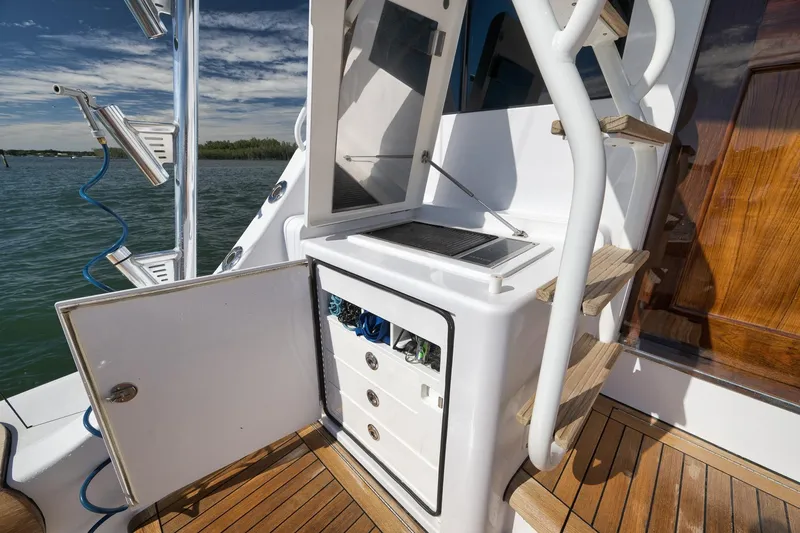 Slide: The Image of 2015 Hatteras GT70 yacht deck with storage and ladder, overlooking water. - 24