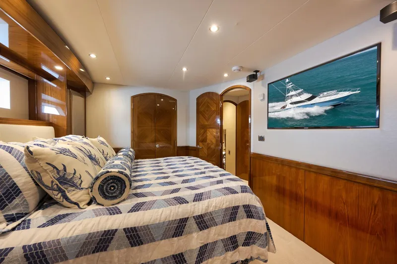 Slide: The Image of Luxurious 2015 Hatteras GT70 yacht bedroom with elegant wood finishes and nautical decor. - 44