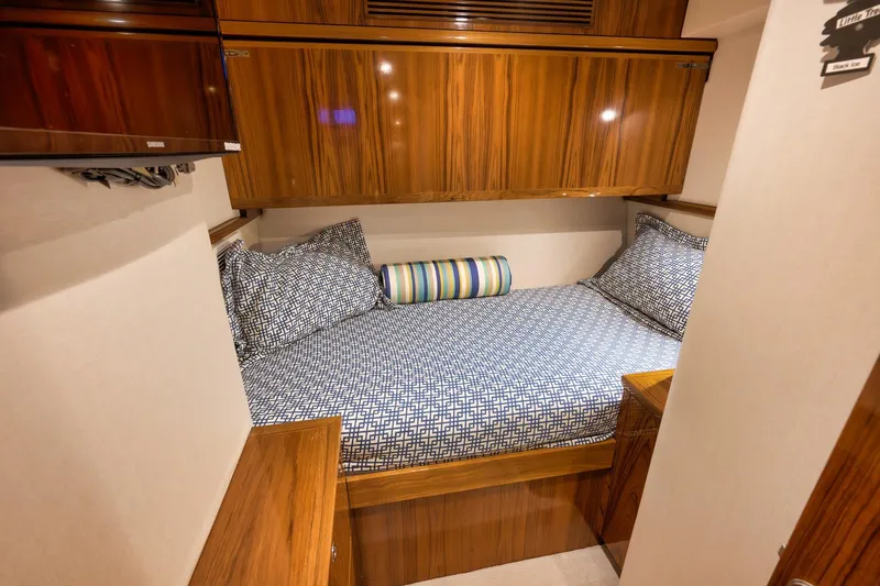 Slide: The Image of Luxurious cabin interior of 2015 Hatteras GT70 yacht with wood finish and patterned bedding. - 60