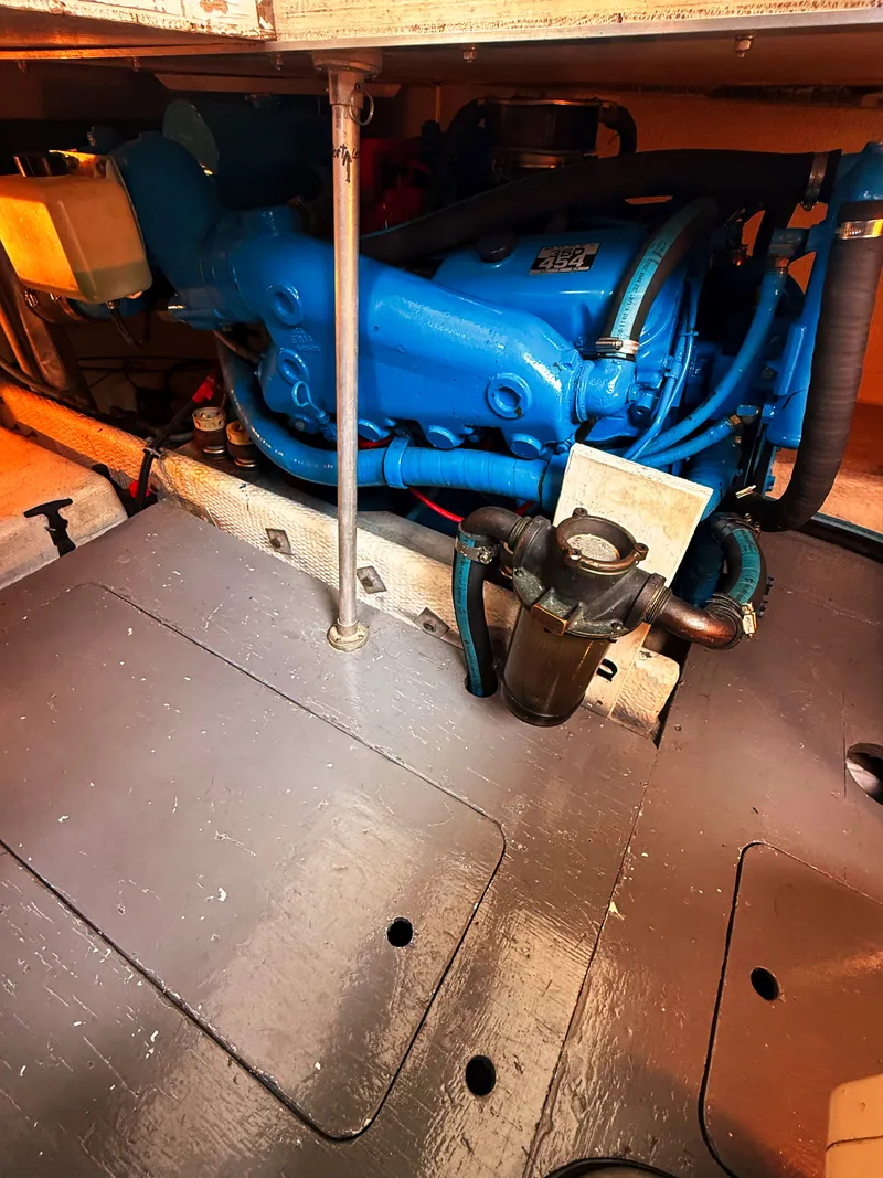 Slide: The Image of A blue-painted engine in a boat's engine room, surrounded by metal parts and hoses. - 20