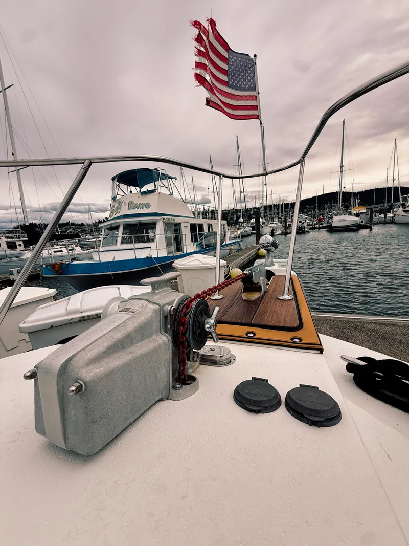 Slide: The Image of 1987 Trojan International 10.8 Meter Sedan in harbor with American flag. - 18