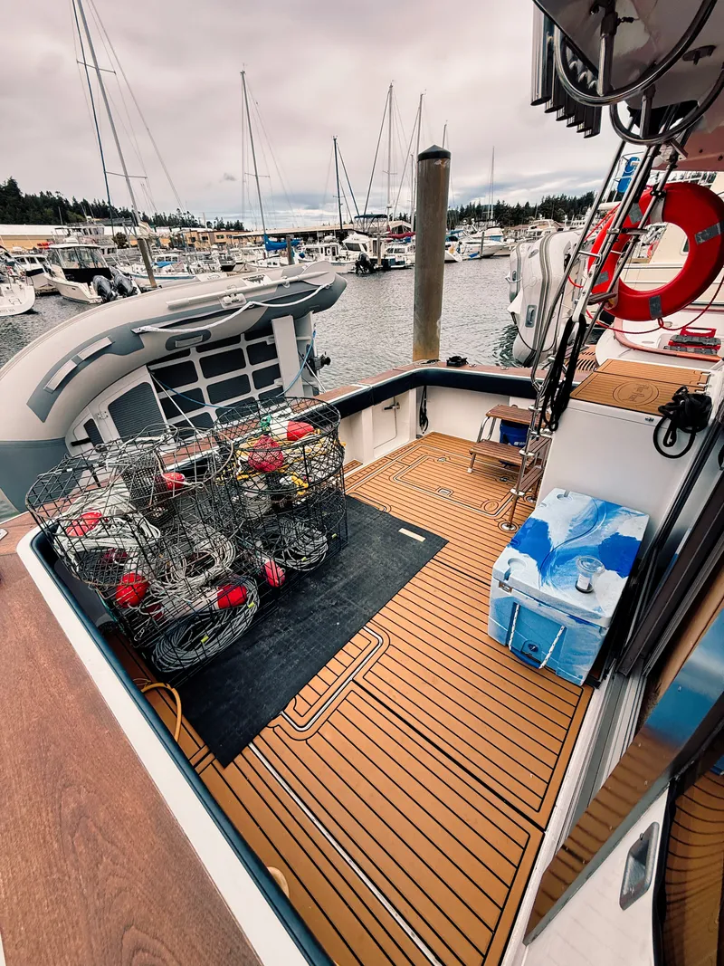 Slide: The Image of The image shows the deck of a 1987 Trojan International 10.8 Meter Sedan with crab pots. - 17