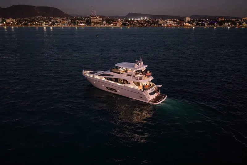 Slide: The Image of Luxurious 2012 Sunseeker Manhattan 73 yacht illuminated at night on calm waters. - 19