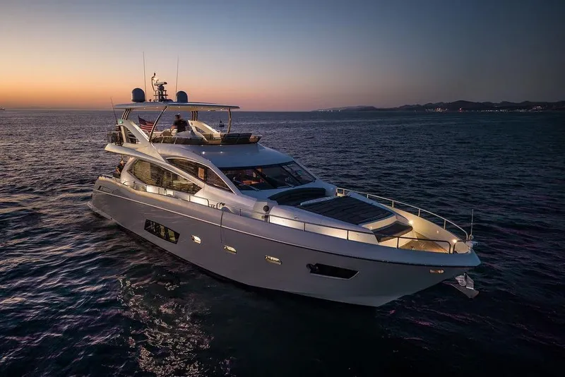 The Image of Luxurious 2012 Sunseeker Manhattan 73 yacht cruising at sunset on open water. - 0