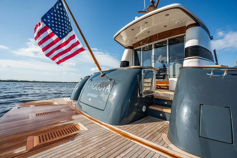 Slide: The Image of 2006 Vicem 62 Custom yacht with American flag, elegant wooden deck, and sleek design. - 17