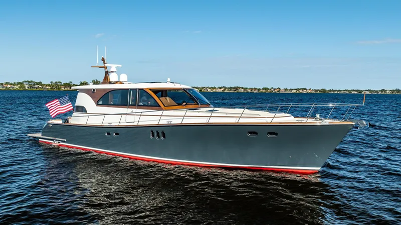 Slide: The Image of 2006 Vicem 62 Custom yacht cruising on open water, displaying sleek design and American flag. - 10