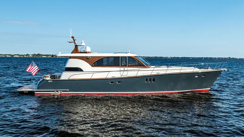 Slide: The Image of 2006 Vicem 62 Custom yacht on open water, displaying sleek design and American flag. - 9