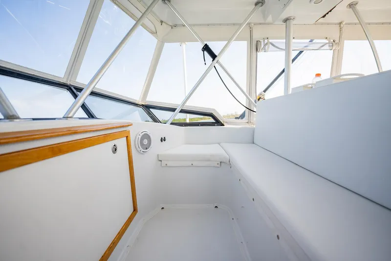 Slide: The Image of Interior of 1991 Jersey 42 Convertible Sportfisherman boat, featuring white seating and wood accents. - 32