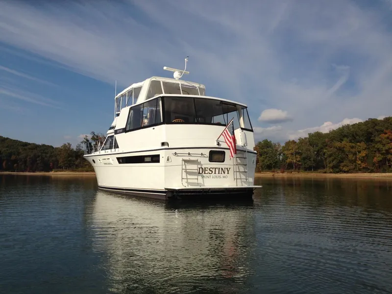 Slide: The Image of Eine weiße Motoryacht mit dem Namen "Destiny" liegt ruhig auf einem See, umgeben von Bäumen. - 1