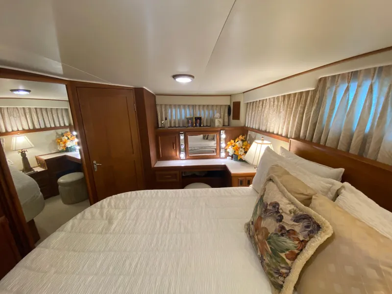 Slide: The Image of Das Bild zeigt eine gemütliche Kabine mit einem großen Bett, Holzmöbeln und dekorativen Kissen. - 41