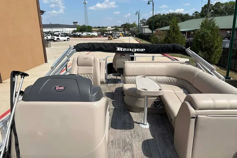 Slide: The Image of 2024 Ranger Reata 220F pontoon boat with beige seating and a central table. - 7