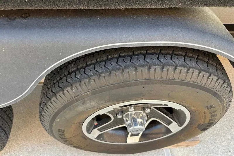 Slide: The Image of 2024 Ranger Reata 220F trailer tire and wheel close-up, showcasing tread and rim design. - 11
