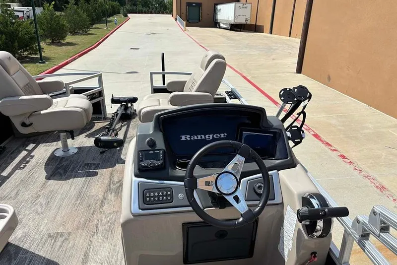 Slide: The Image of 2024 Ranger Reata 220F boat interior with steering wheel and seating. - 5