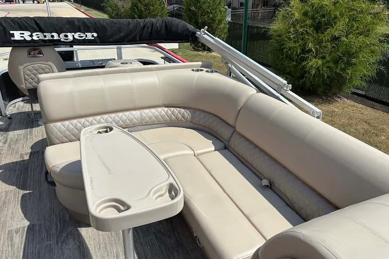 Slide: The Image of 2024 Ranger Reata 220F boat interior with beige seating and table. - 6