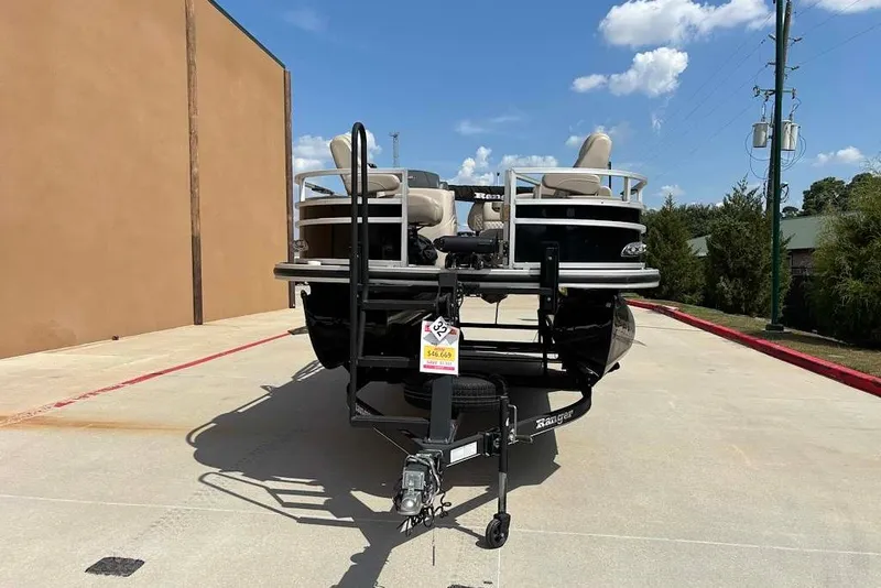 Slide: The Image of 2024 Ranger Reata 220F pontoon boat on trailer, parked outdoors under blue sky. - 3