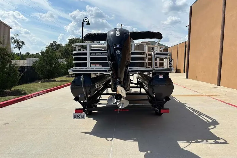 Slide: The Image of 2024 Ranger Reata 220F pontoon boat with outboard motor, parked outdoors. - 2