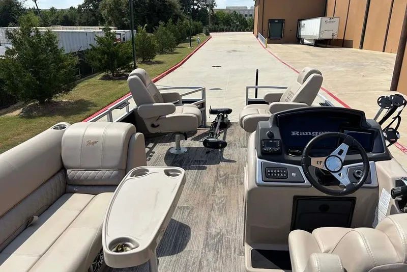 Slide: The Image of 2024 Ranger Reata 220F pontoon boat interior with plush seating and modern dashboard. - 9