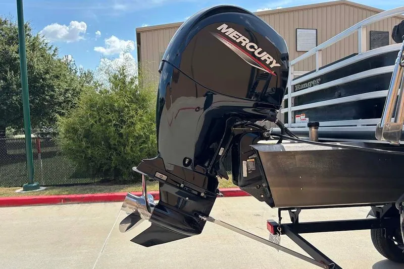 Slide: The Image of 2024 Ranger Reata 220F boat with Mercury outboard motor in a sunny outdoor setting. - 12