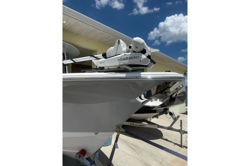 Slide: The Image of 2025 Sea Hunt Gamefish 27CB boat with Garmin equipment, docked under a clear blue sky. - 14