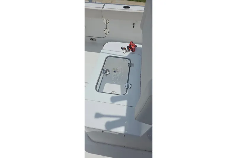 Slide: The Image of 2025 Sea Hunt Gamefish 27CB boat deck with storage compartment and keys. - 25