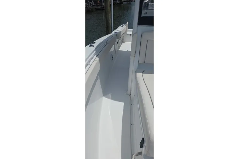 Slide: The Image of 2025 Sea Hunt Gamefish 27CB boat interior, featuring sleek white seating and deck design. - 16
