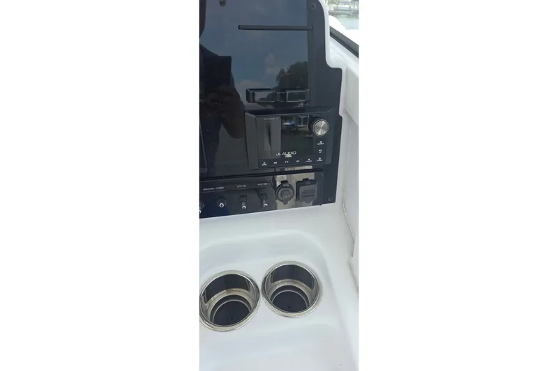 Slide: The Image of 2025 Sea Hunt Gamefish 27CB console with audio controls and cup holders. - 23